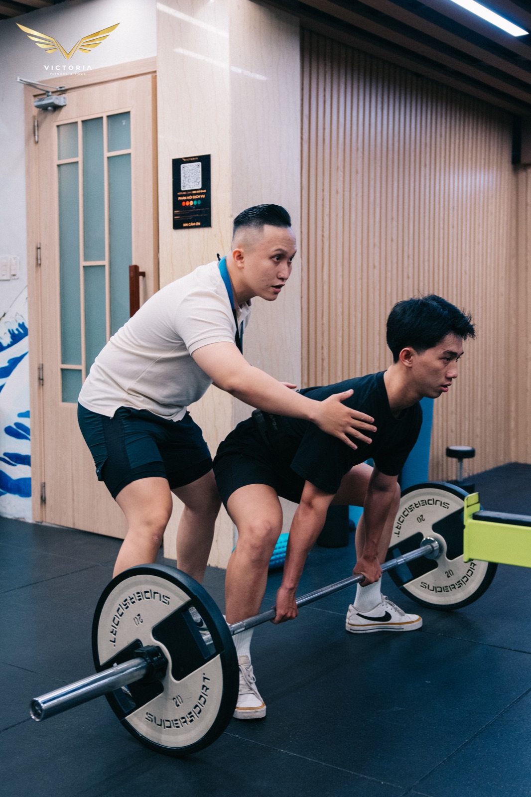 Huấn luyện viên Victoria chỉnh tư thế deadlift cho hội viên trong buổi PT 1:1